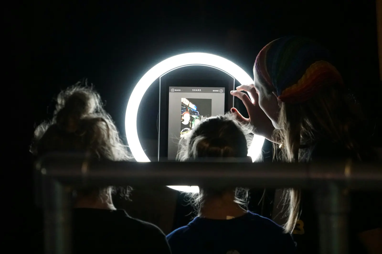 Guests posing in front of a tablet photo booth with a ring light