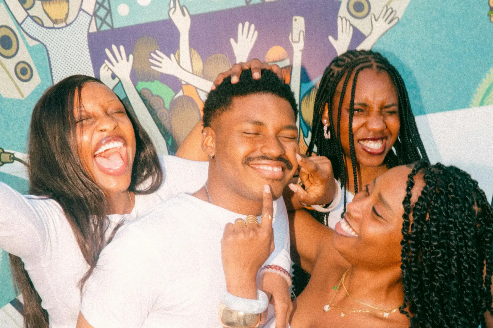 Four friends laughing and squeezing together for a photo