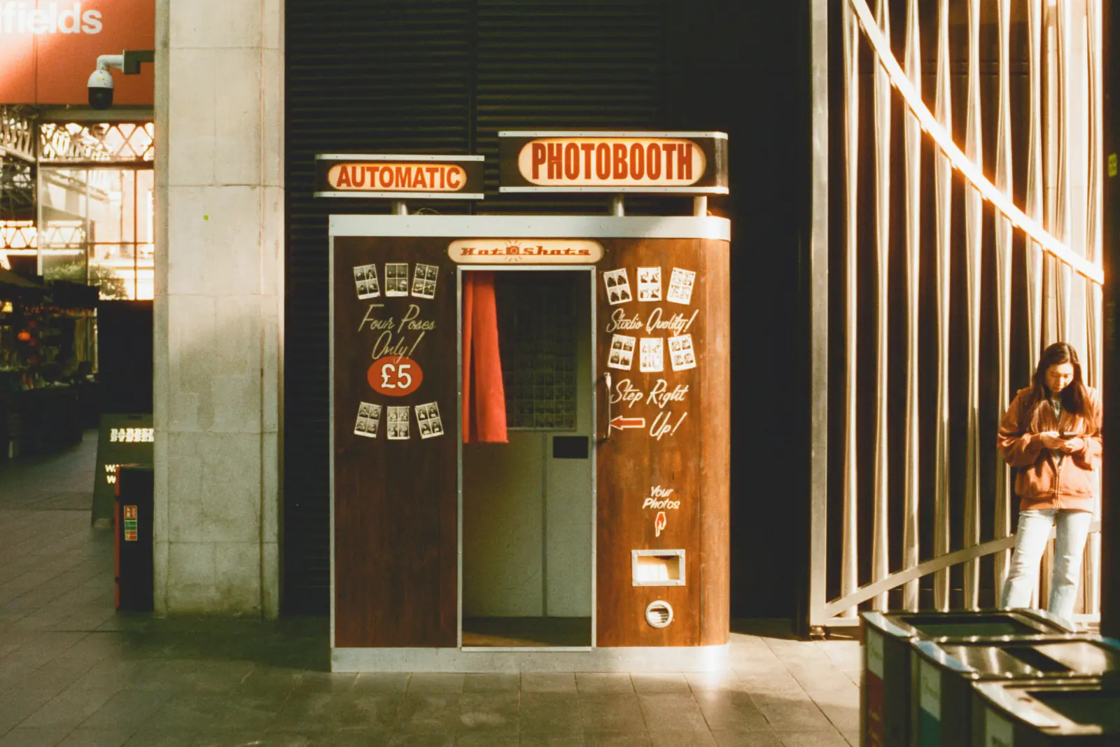 Classic coin-operated photo booth with a curtain in warm evening light